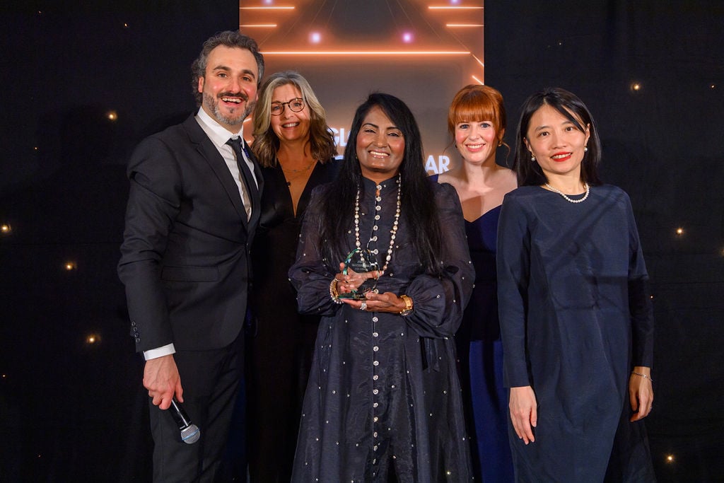 Professor Vijay Kunadian is pictured receiving an award on stage with members of her team and award presenters 