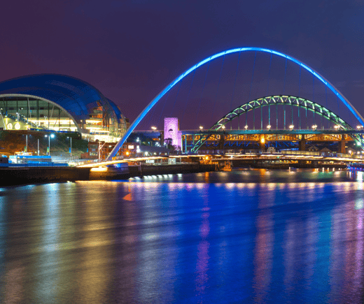 The River Tyne at night with two of its bridges lit brightly by lights 